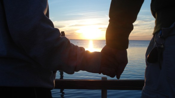 sunset holding hands